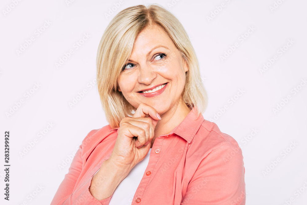 Close up portrait of happy smiling and beautiful blonde senior woman isolated in studio and posing with smile on camera Close up portrait of happy smiling and beautiful blonde senior woman isolated in studio and posing with smile on camera