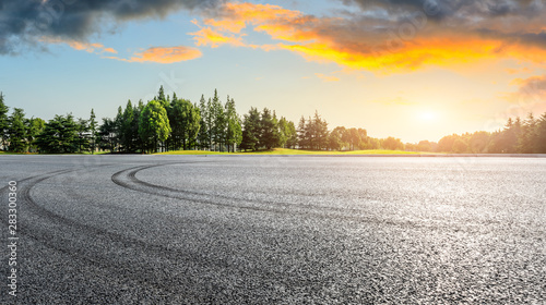 Asphalt race track and green woods nature landscape at sunset © ABCDstock