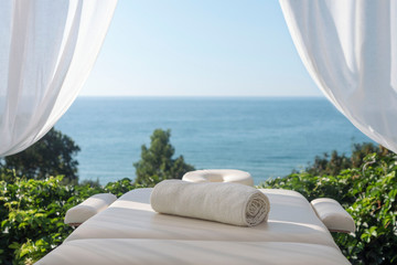 Foto auf Acrylglas Massagesalon Massage table with sea view  © Serge Touch