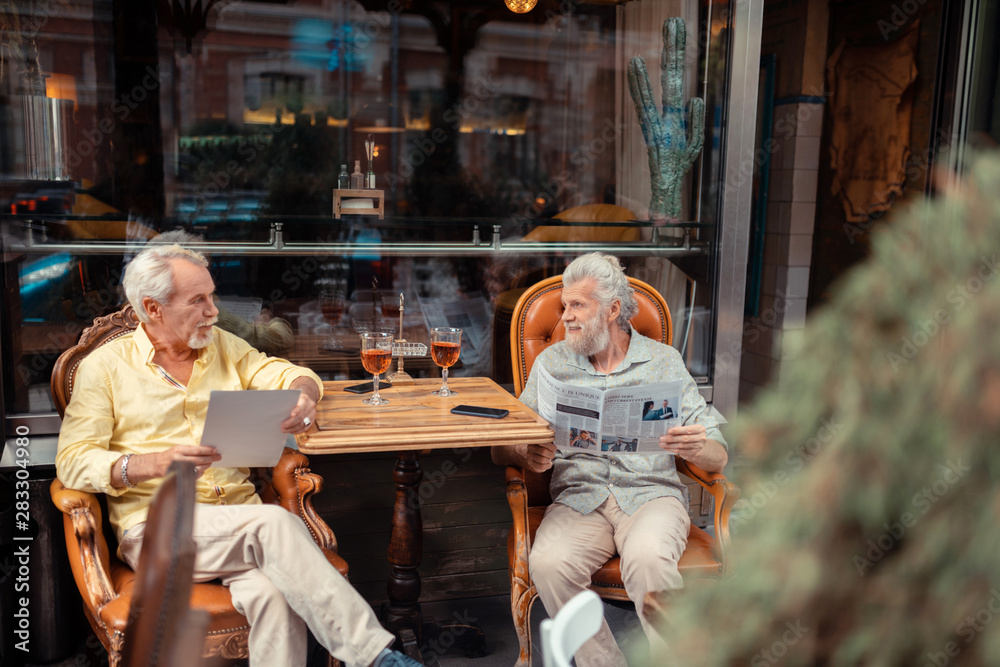 Retired men drinking whisky and reading morning news