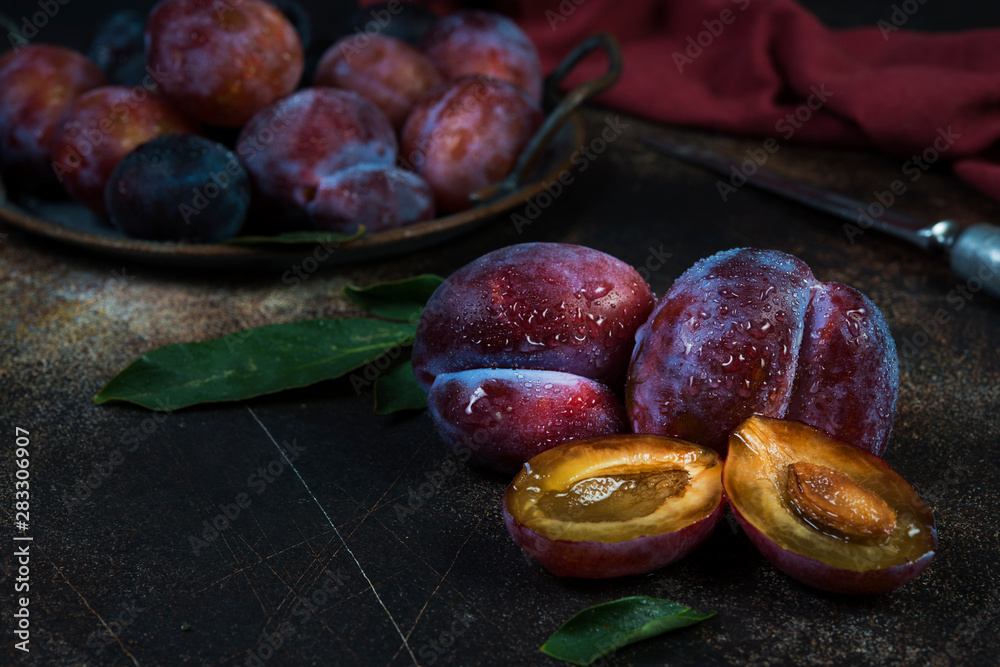 Fototapeta premium Still life of fresh seasonal plums with water droplets