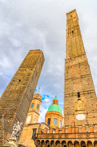 Two medieval towers of Bologna Le Due Torri: Asinelli and Garisenda and Chiesa di San Bartolomeo Gaetano church on Piazza di Porta Ravegnana square in old historical city centre, Emilia-Romagna, Italy photo