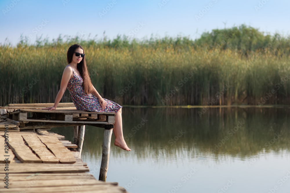 young woman sitting on wooden bridge