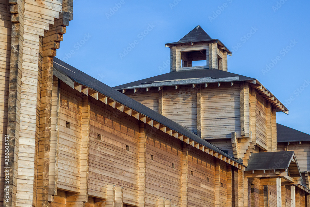 high defensive wall of an ancient wooden fortress with a bell tower high defensive wall of an ancient wooden fortress with a bell tower