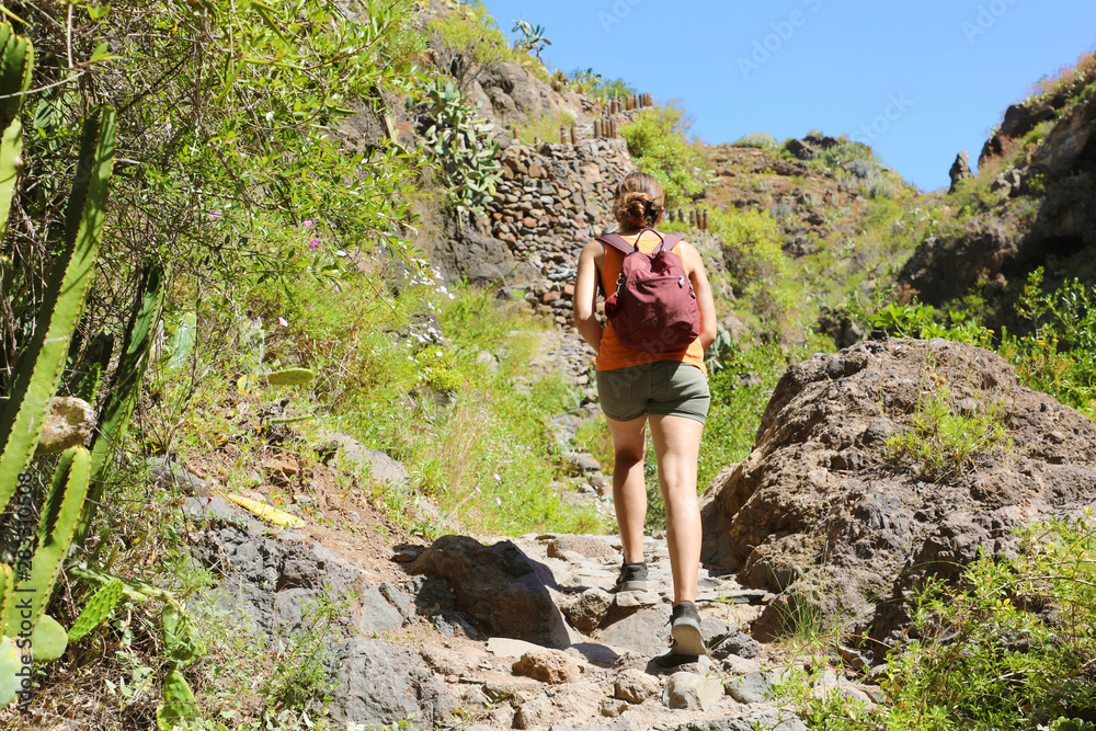 Young hiker woman with backpack climbs steep rocky terrain. Young hiker woman with backpack climbs steep rocky terrain.