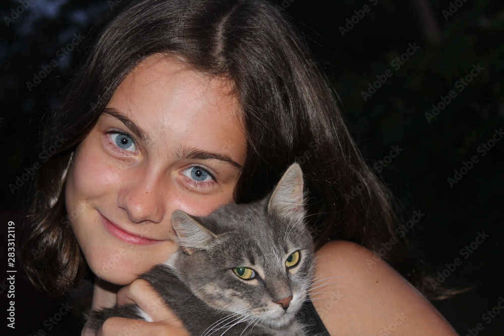 Girl with unusual eyes with a gray kitten in her arms