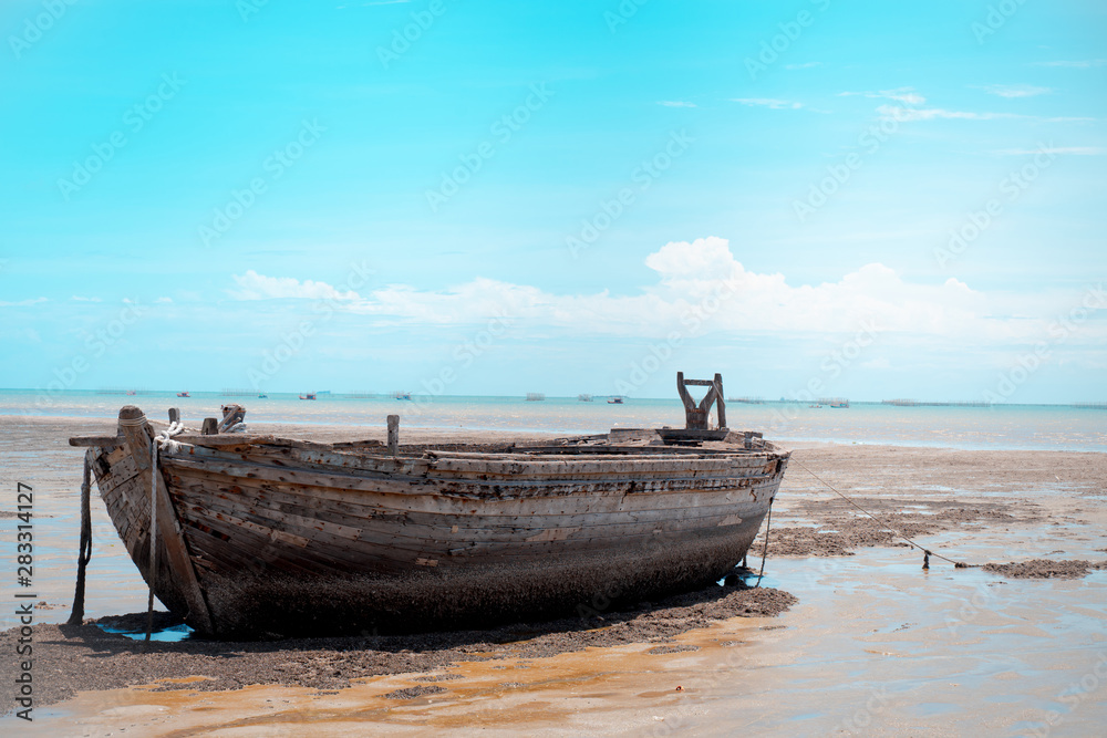 Old wooden boat on the beach in the middle of the sun by the sea Old wooden boat on the beach in the middle of the sun by the sea