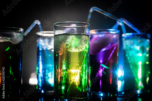 collection of colorful shots with lemon on bar; set of alcohol mini cocktail shooters with lime;