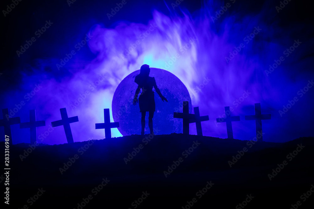 Naklejka premium Girl walking alone in the cemetery at night.