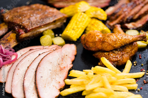 Grill restaurant menu. Roasted meat, poultry assortment, French fries, baked Bonduelle corn. photo