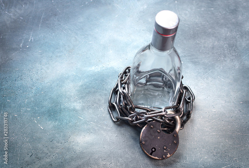 Bilde på lerret Alcoholism, alcohol addiction concept with alcohol drink bottle and chain with lock