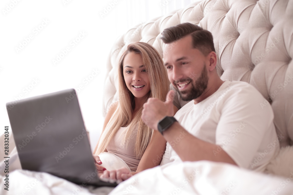 young couple browsing their favorite vidio on their laptop young couple browsing their favorite vidio on their laptop