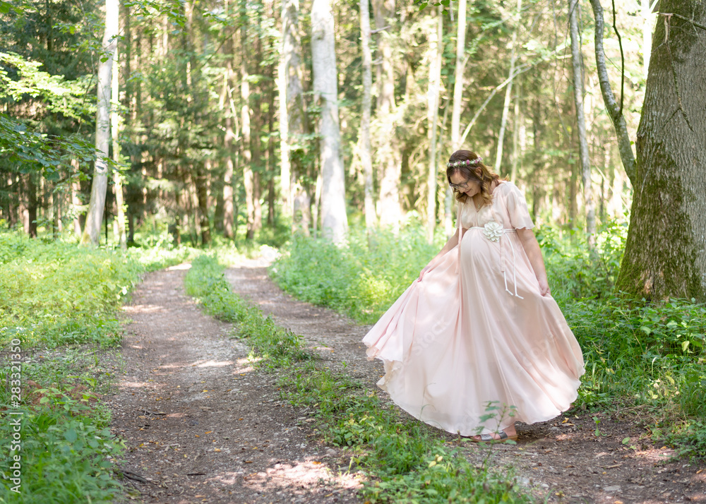Frau tanzt im Wald vor Freude, Schwangerschaft, bald Mama