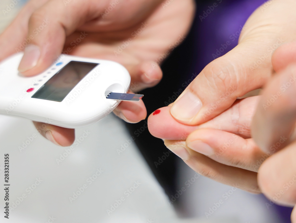 Close up of Doctor taking sample of diabetic patient's blood using lancet pen,Healthcare and Medical concept Close up of Doctor taking sample of diabetic patient's blood using lancet pen,Healthcare and Medical concept