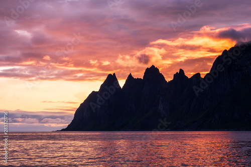 View over Oksen Mountain range devils jaw at Ersfjord in colorful impressive sunset, Senja, Norway