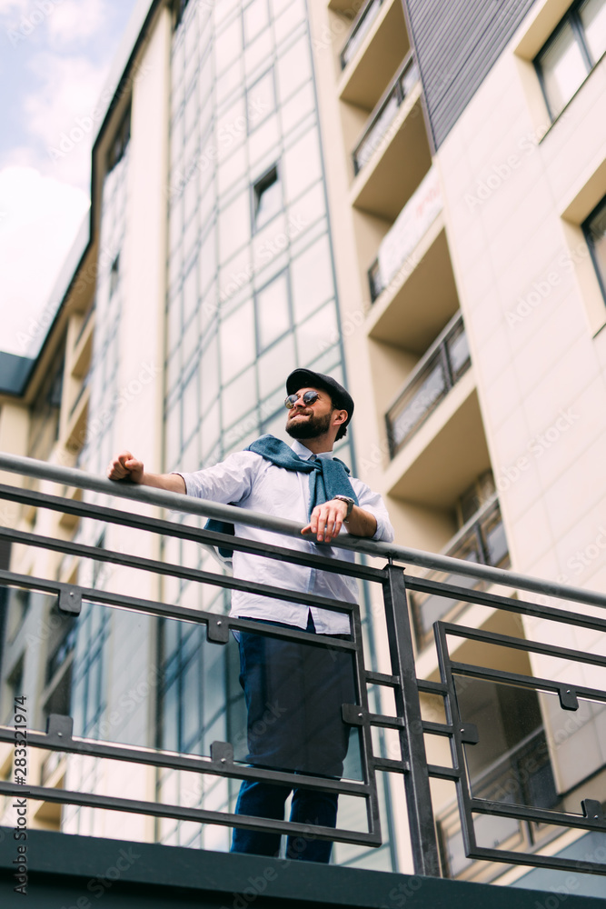 Handsome man standing on the bridge outdoors on the street.