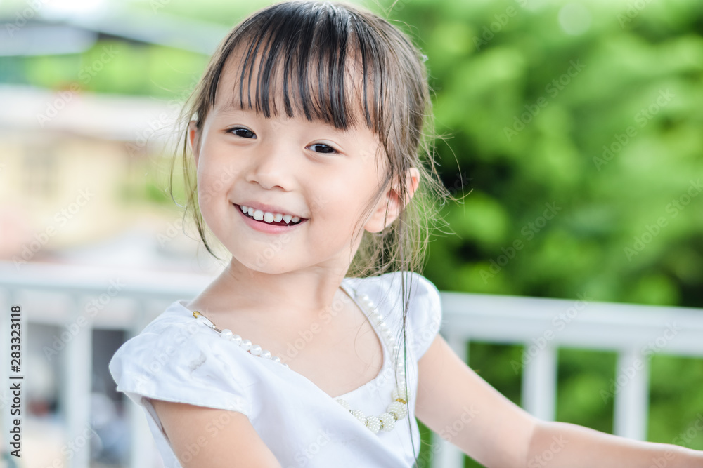 Asian little girl outdoors with smiley face feeling relax be happy in good day Asian little girl outdoors with smiley face feeling relax be happy in good day