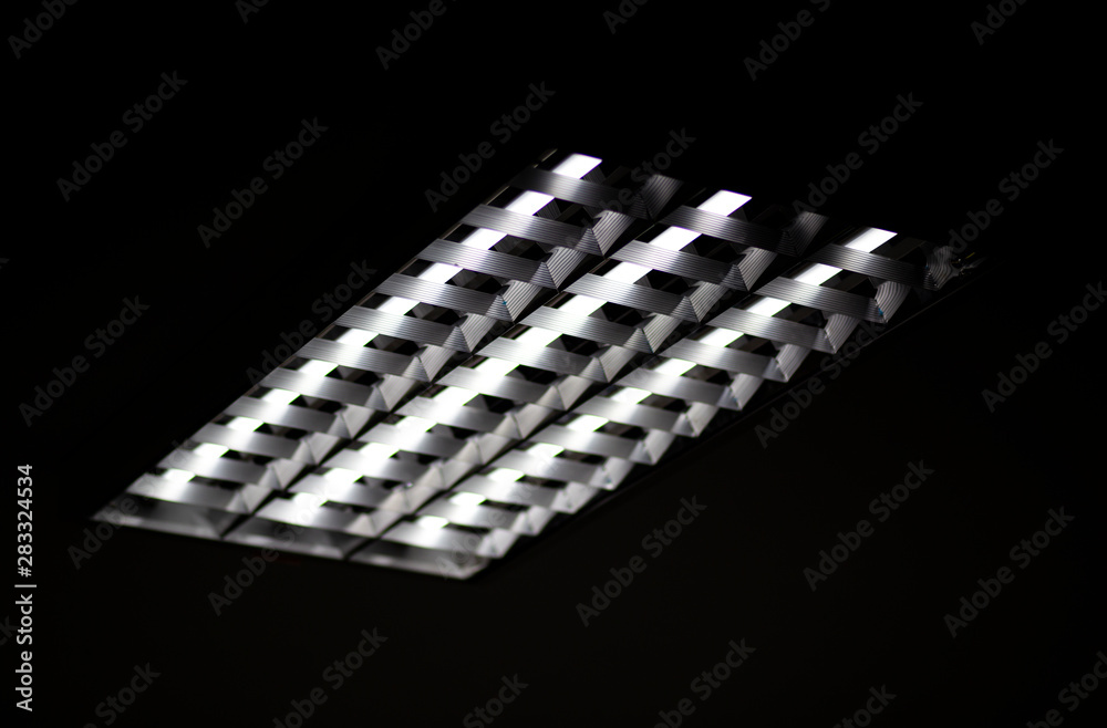 Fluorescent lamps and aluminum tracks on the office ceiling Fluorescent lamps and aluminum tracks on the office ceiling