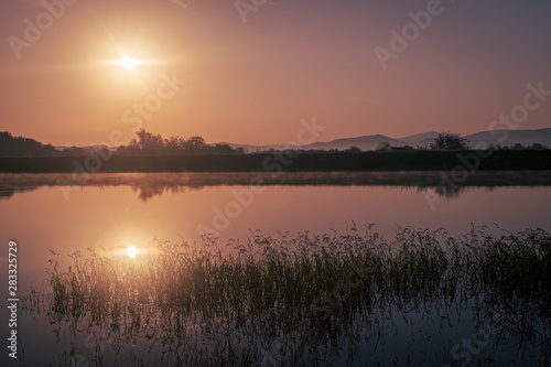 Sun rising over the calm peacful and tranquil lake in Bulgaria