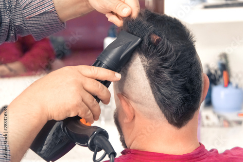 A man with a mohawk in a barbershop. Laying, drying.