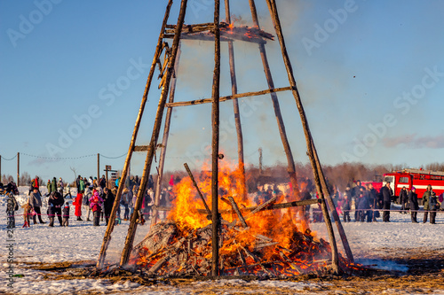 Etnomir, Russia - March 2019: Burning effigy Maslenitsa at sunset, Russian spring holiday Maslenitsa (Maslenica) photo