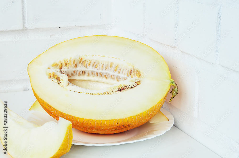 Ripe yellow melon on white background. Ripe yellow melon on a white table.