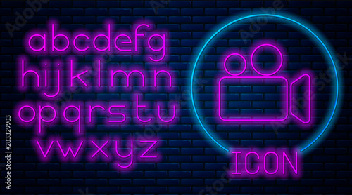Glowing neon Movie or Video camera icon isolated on brick wall background. Cinema camera icon. Neon light alphabet. Vector Illustration