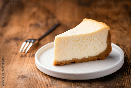 Fotografiet Cheesecake slice, New York style classical cheese cake on wooden background