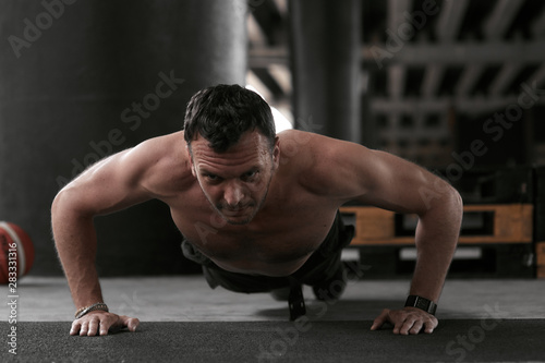 Muscular man pushing up on the floor