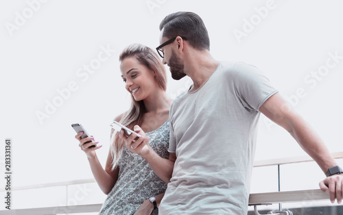 young couple reading text message on smartphone