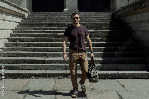 Photos a man walks with a bag along the street