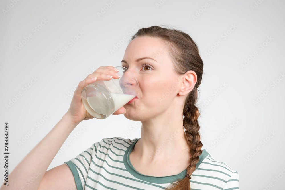 young woman drinking a glass of fresh milk
