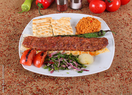 Adana barbecue service on a plate with grits, tomatoes photo