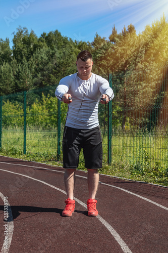 athletic man at the stadium with a skipping rope. Healthy lifestyle. Sport activities on the street