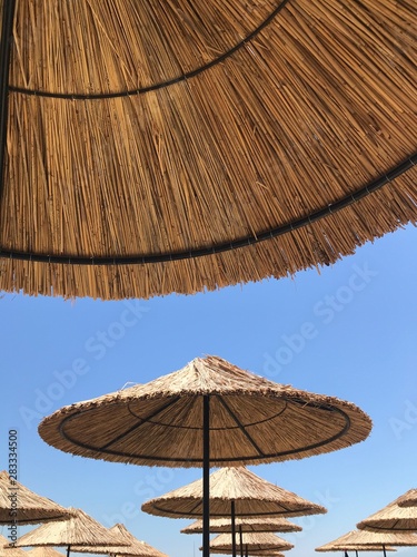 Bamboo sun umbrella against blue sky 