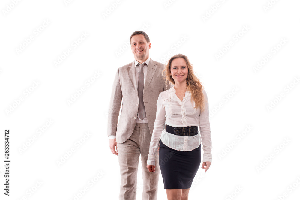Studio shot of two smiling young employees or a businessman, a man and a woman, confidently purposefully walk. Studio shot of two smiling young employees or a businessman, a man and a woman, confidently purposefully walk.