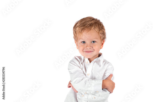 Waist up portrait of a little smiling boy against a white background with copy space in the studio