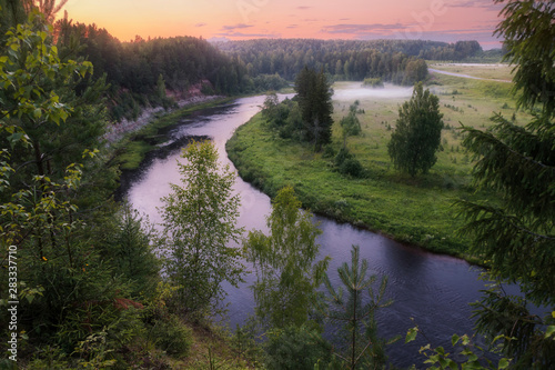 iew from the hill on a misty field and the river at sunset