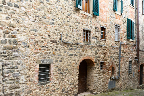 Fototapeta Naklejka Na Ścianę i Meble -  The Town Of Barga. Italy. Summer 2019. Street in the Central part of the historic center. Different Windows in the stone wall.