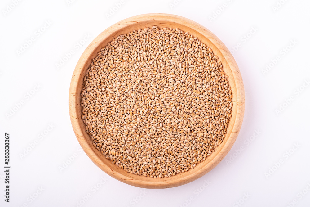 Wheat seeds grains in wooden bowl, top view, flat lay, isolated on white background Wheat seeds grains in wooden bowl, top view, flat lay, isolated on white background