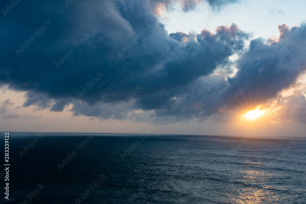 Heavy clouds during sunrise with wonderful steel looking sea