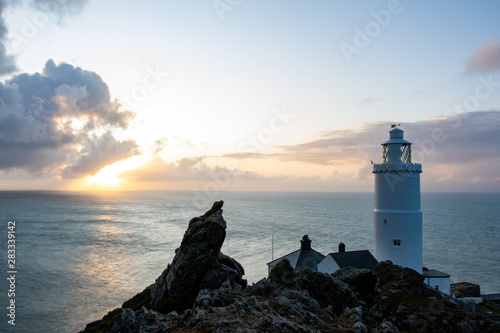 Lighthouse during sunrise in a view from top of a rock near the tower
