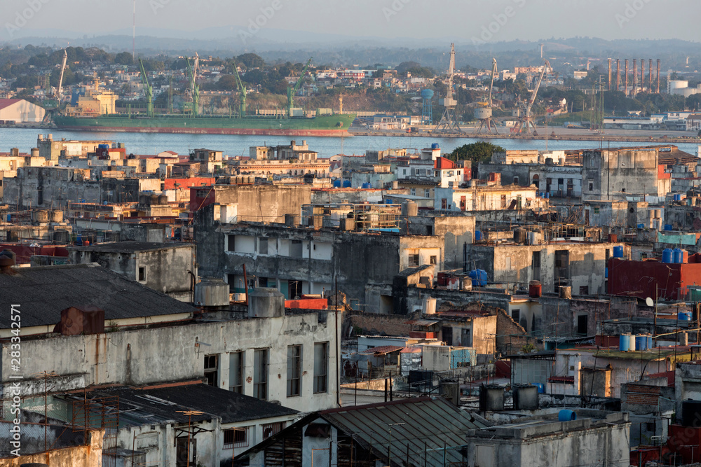 Rooftop view of the port area of old havana cuba showing a cluster of old buildings, water and ship
