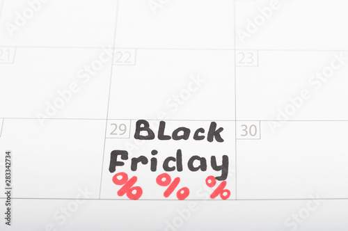 Inscription Black Friday on calendar 2019 and and percent sign, close-up