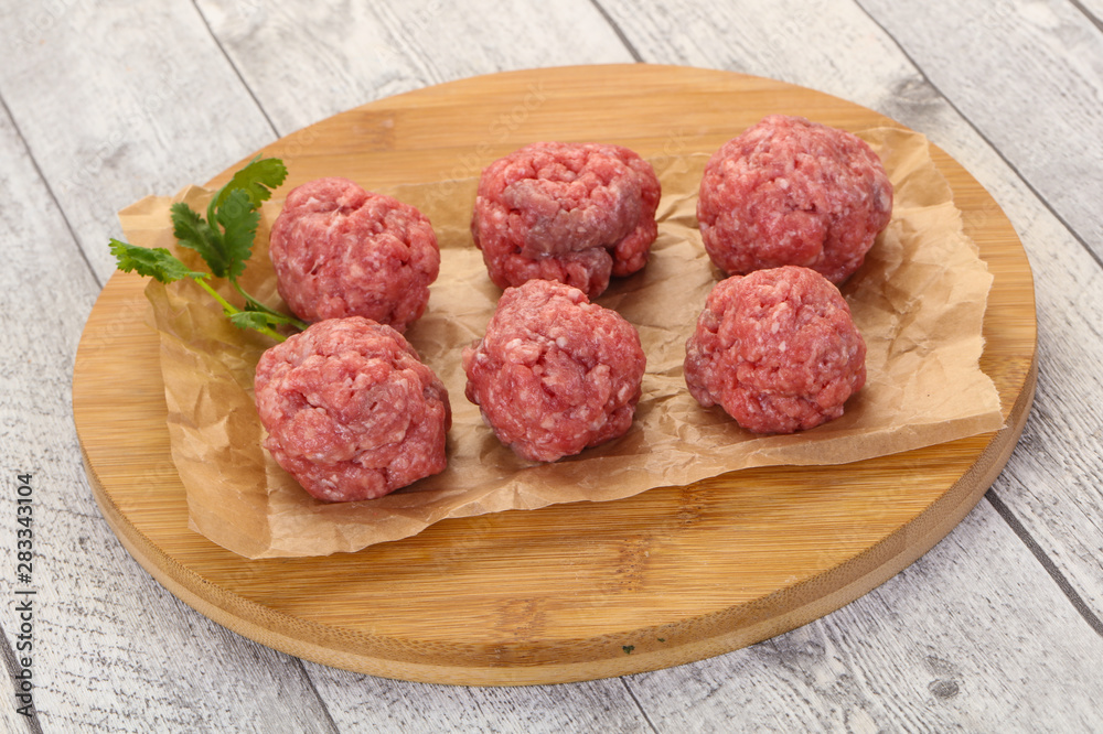Raw meatball over wooden background Raw meatball over wooden background