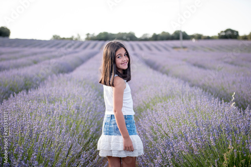 Fototapeta Naklejka Na Ścianę i Meble -  Pretty little girl in a field of lavender flowers
