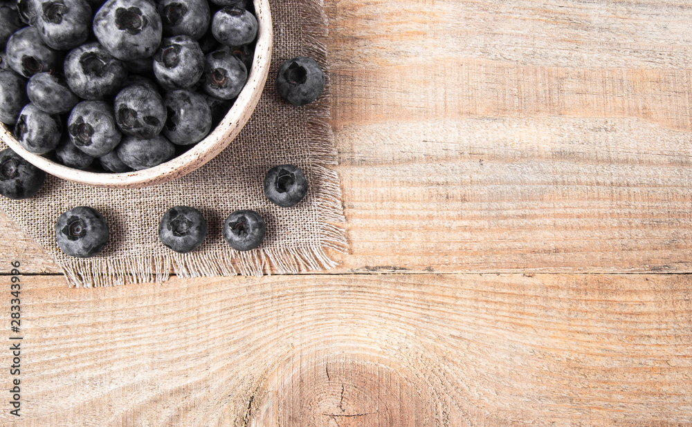 Raw fresh huckleberry in a bowl. Wooden background. Raw fresh huckleberry in a bowl. Wooden background.