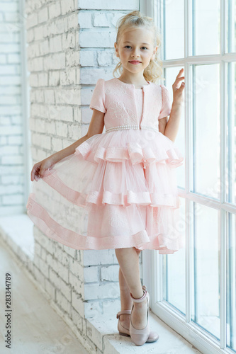 Little fashionable girl in a beautiful dress. 