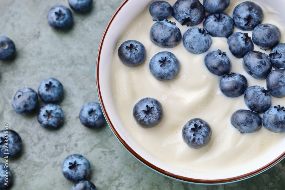 Bowl with yogurt and blueberries on table, top view Bowl with yogurt and blueberries on table, top view