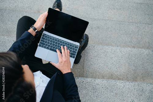 Valokuva Close up man in classic suit sitting on stairs outdoor working on modern laptop